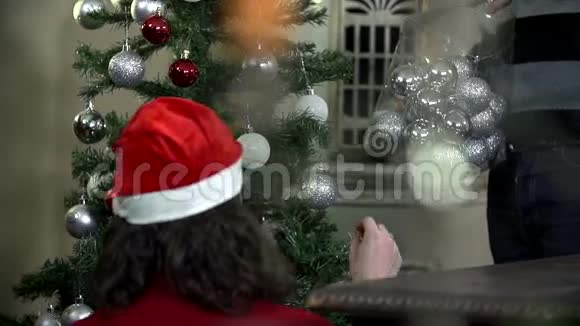 女孩装饰大圣诞树男人帮忙视频的预览图