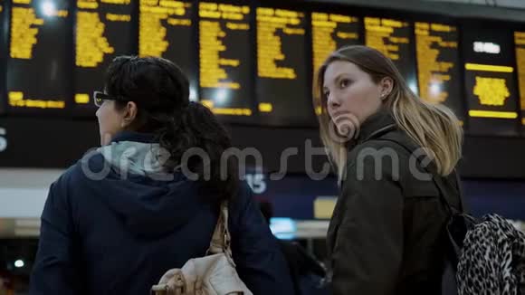 两个女孩在火车站检查出发台视频的预览图