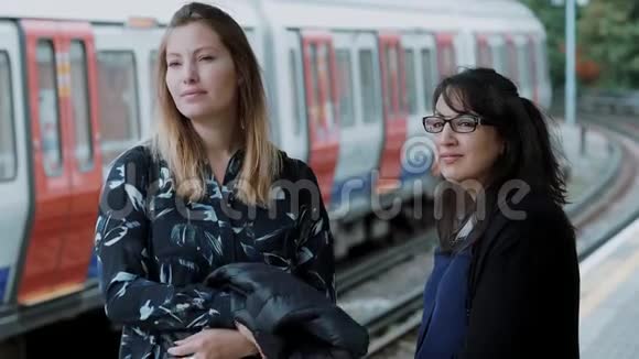 两名年轻女子在伦敦地铁站等地铁视频的预览图