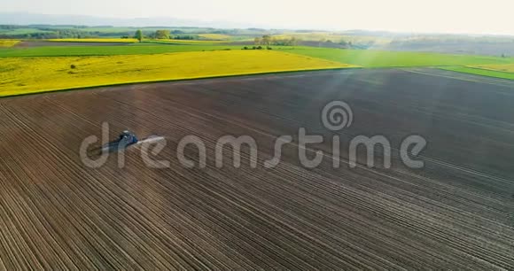 农业农用拖拉机喷洒场的无人机视图视频的预览图