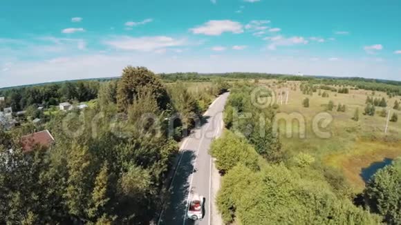 老式白色轿车在高速公路槽林上的航拍镜头视频的预览图