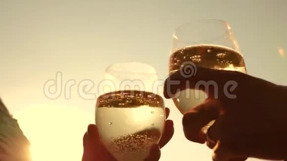 香槟在阳光下闪耀和泡沫情侣们在夕阳的映衬下捧着酒杯和起泡葡萄酒视频的预览图