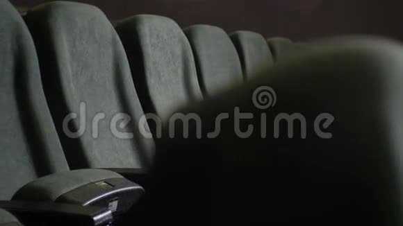 黑暗电影院大厅一排空灰椅特写视频的预览图