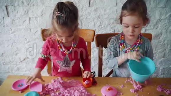 两个小女孩在桌子上玩动能沙视频的预览图