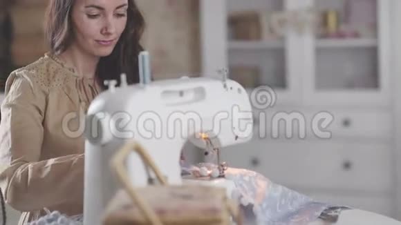 一个女人坐在现代缝纫机旁享受手工艺和爱好视频的预览图