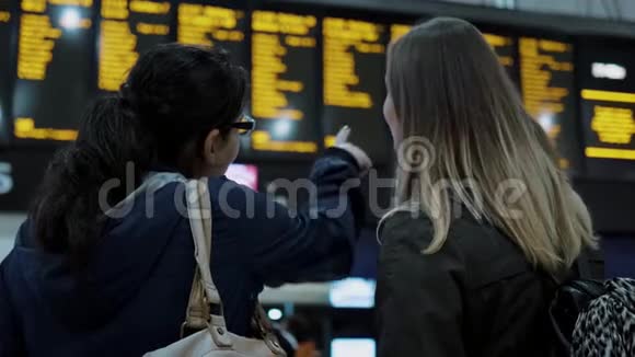 两个女孩在火车站检查出发台视频的预览图