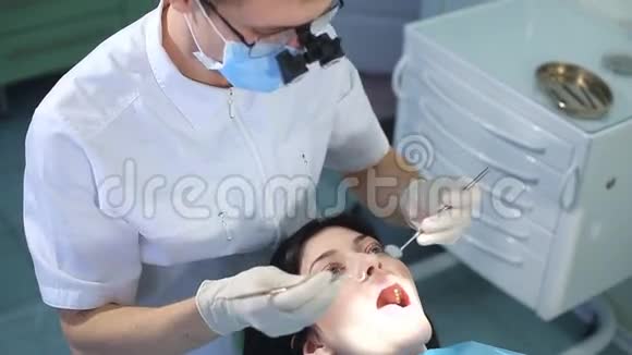 牙医开始检查一个漂亮女孩的口腔视频的预览图