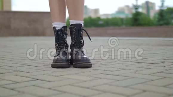 穿着重臂靴走走的女性腿的近镜头特写镜头时尚女性穿着皮靴走进来视频的预览图