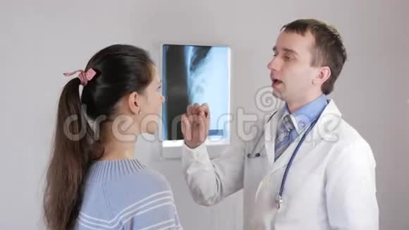 一位年轻的男医生检查一位年轻妇女的喉咙人说诊断规定治疗视频的预览图