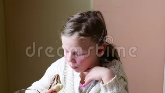 小女孩有零食可爱的小女孩吃巧克力奶油在卷上家庭观念视频的预览图