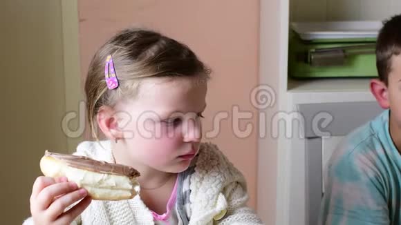 小男孩和小女孩吃点心兄弟姐妹吃巧克力奶油摊在卷上家庭观念视频的预览图