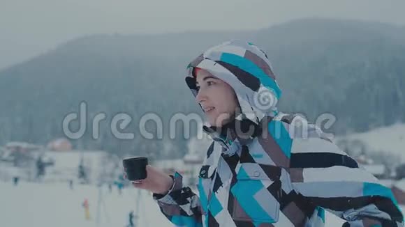 放松的女孩在户外喝酒在滑雪场喝茶的女孩视频的预览图