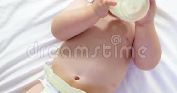 可爱的婴儿躺着喝着他的婴儿奶瓶视频的预览图