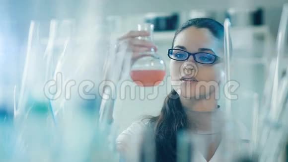 在实验室里用烧瓶工作的女人的框架视频的预览图
