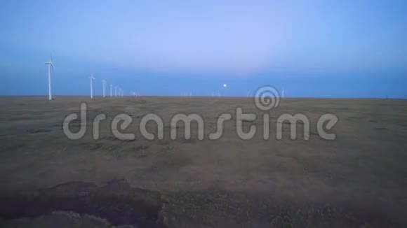 4K美丽的傍晚日落时分大片白色的风电场坐落在大草原上视频的预览图
