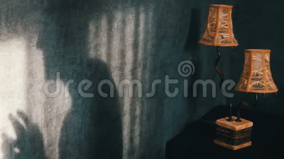 可怕的阴影在哥特式黑暗的房间旁边一盏老式的黄灯不祥的手指一个鬼魂或女巫视频的预览图