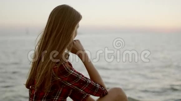 坐在海边望着地平线的年轻女子视频的预览图