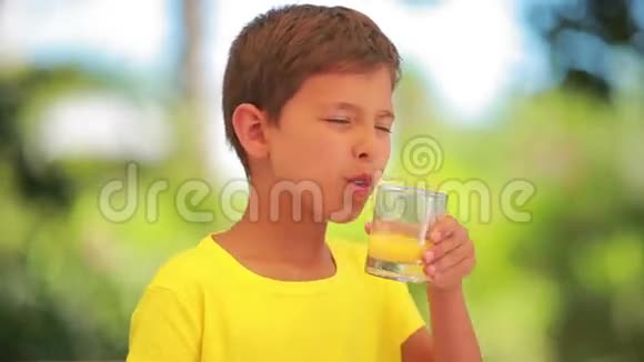 男孩从杯子里喝橙汁视频的预览图