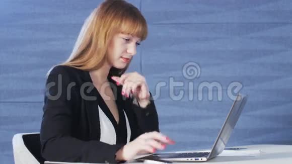 使用电脑时微笑的年轻美女视频的预览图