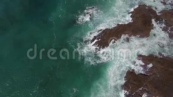 石质海岸绿宝石海水中的白色巨浪4k高空视频的预览图