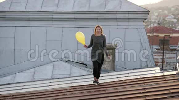 女人觉得在屋顶上带着气球跑步很开心视频的预览图