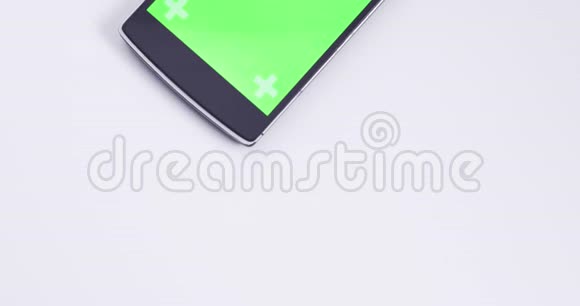 带有彩色绿色屏幕和跟踪标记的白色桌子上的烟雾电话倾斜特写视频的预览图