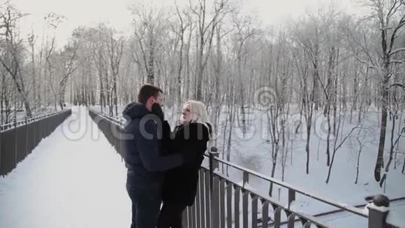 美丽的年轻夫妇拥抱和交谈在一个城市冬季公园视频的预览图