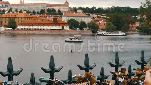 布拉格老城和伏尔塔瓦河的景色以及船经过一个女孩站在桥上身上有许多铁视频的预览图
