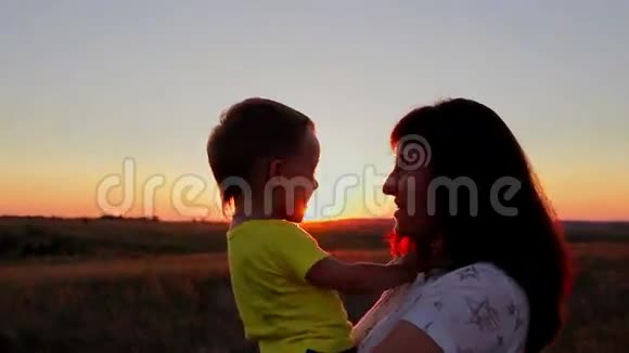 日落时分妈妈抱着孩子亲吻他视频的预览图