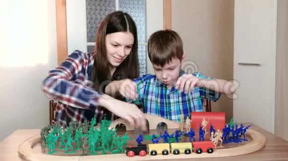 一起玩妈妈和儿子正在玩一条木制铁路火车马车和隧道坐着塑料士兵视频的预览图
