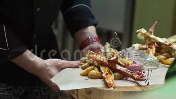 厨师把红小龙虾放在一个大木盘上红蟹的美味触手视频的预览图