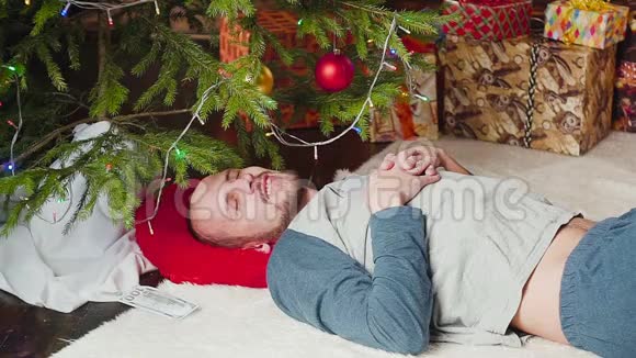 不断下降的钱一个在圣诞树附近睡觉的人视频的预览图