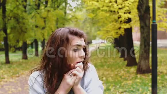 公园里一个害羞的红发少女视频的预览图