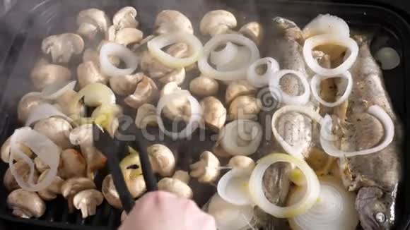 用烤鱼和蘑菇烹饪美味的饭菜视频的预览图