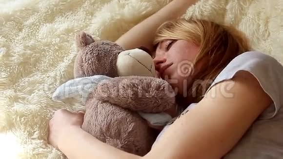 家里卧室里睡着带着泰迪熊的女孩视频的预览图