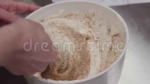 将面包屑和鲜奶油用刮刀混合在碗中视频的预览图