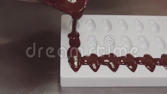 糖果把融化的巧克力倒入白色塑料模具视频的预览图