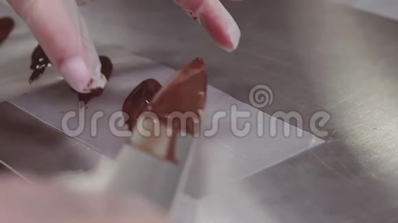 女糕点厨师手戴塑料手套把巧克力放在烹饪条上视频的预览图