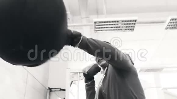 运动健身俱乐部中年轻拳击手在拳击袋上练习的慢动作视频的预览图