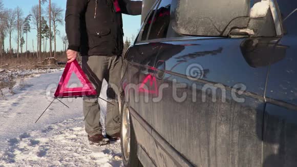 有警告三角的人在冬天靠近汽车行走视频的预览图