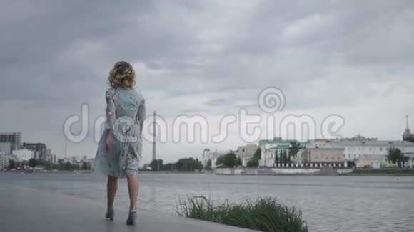穿裙子的女人走在海边视频的预览图