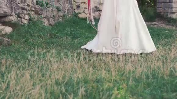 新娘戴着花环在城堡附近挥舞着花束慢慢地视频的预览图