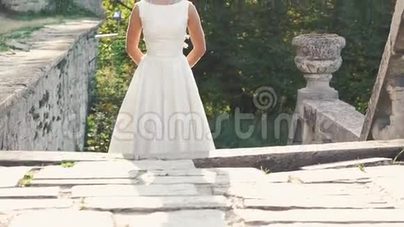 站在楼梯上阳光下的漂亮新娘剪影慢慢地视频的预览图