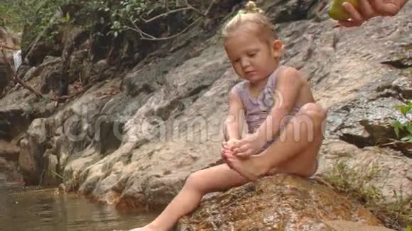 一条条河边的石头上有一条小小的金发女郎清洁视频的预览图