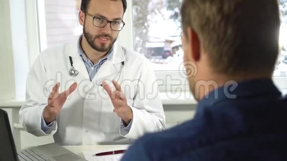 医疗咨询坐在桌边的医生和病人视频的预览图