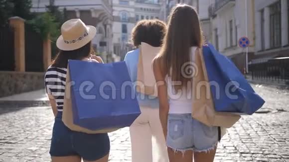 三个拿着购物袋微笑的多种族女孩视频的预览图