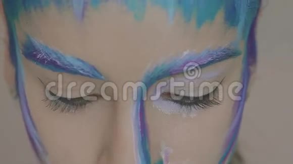 迷人的女孩化妆艺术的雪后看着镜头与绿色的眼睛视频的预览图