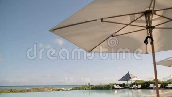 带躺椅和雨伞的豪华度假游泳池视频的预览图