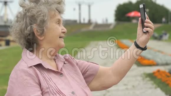 成熟的老妇人用智能手机拍照视频的预览图