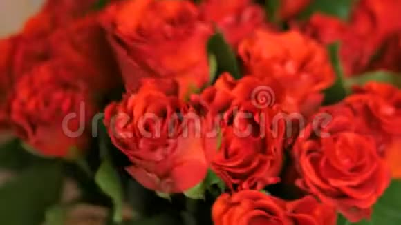 专业花艺师在工作坊为花束准备红玫瑰视频的预览图